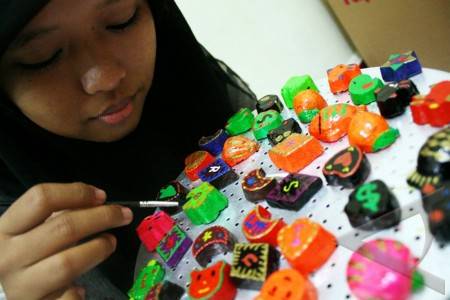 Dewi (20) membuat aksesoris dan souvenir dari bahan daur ulang kertas di Jalan Tanjung Sari Medan, Sabtu (23/1). Para perajin itu mampu menghasilkan 200 ... - 371a4-aneka-kerajinan-kertas-daur-ulang